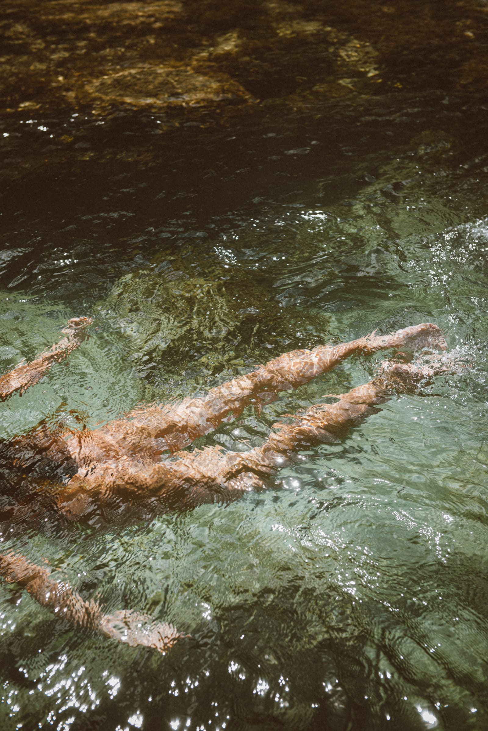 A swimmer gliding through clear green water